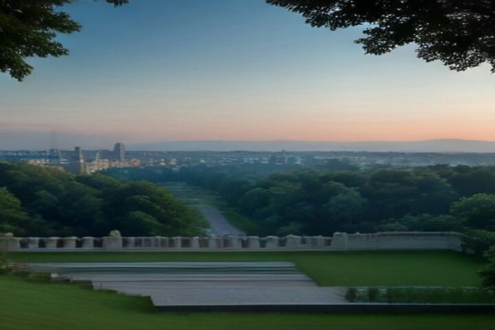 Terraza de piedra con balaustrada blanca neoclásica que mira hacia un bosque extenso y la ciudad al atardecer