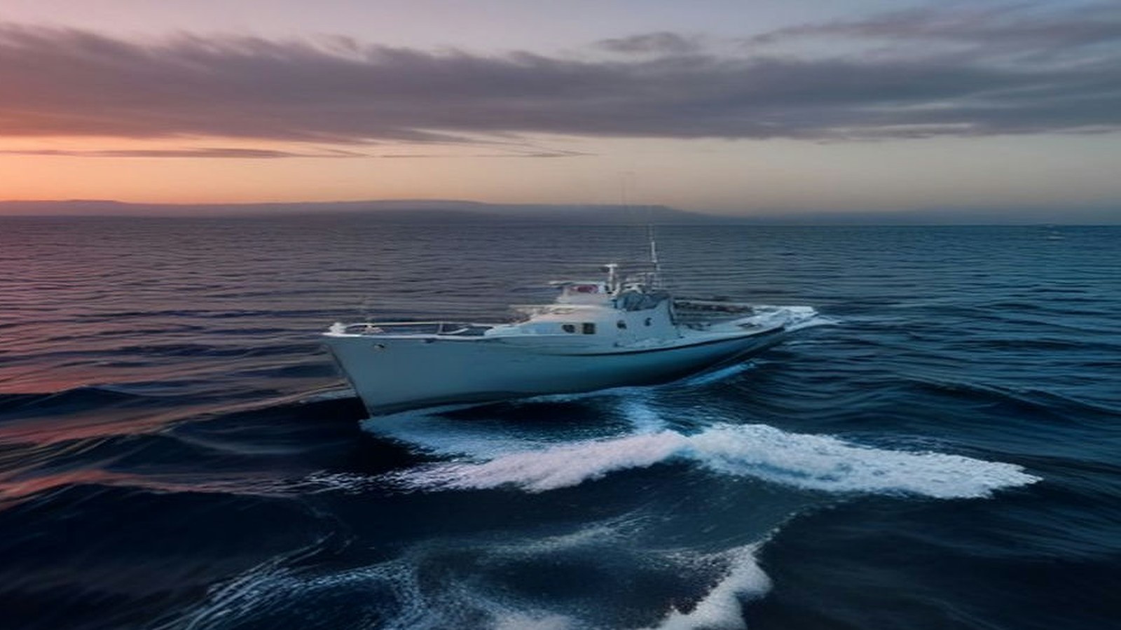Embarcación blanca navegando en mar abierto y dejando una estela de espuma al atardecer