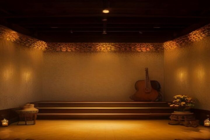 Pequeño escenario con tarima de madera, una guitarra tradicional, flores y velas encendidas bajo luz dorada