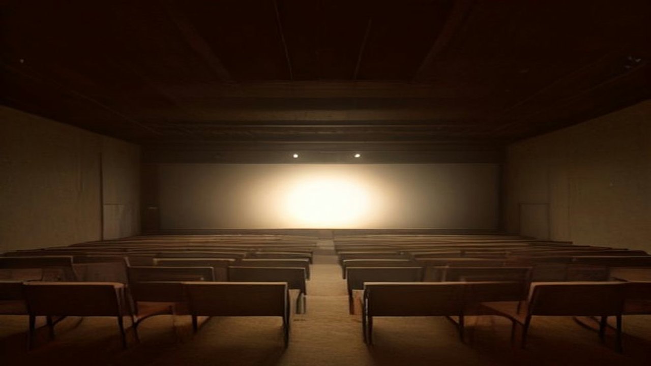 Sala en penumbra con filas de bancas de madera vacías frente a un escenario iluminado por un haz de luz cálida