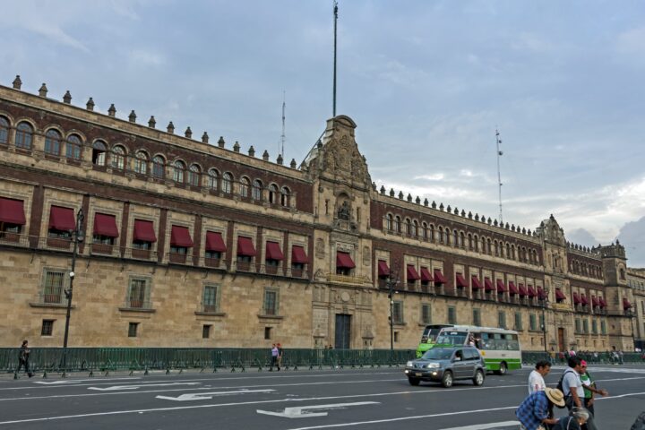 Fachada del Palacio Nacional frente al Zócalo de la Ciudad de México con tránsito vehicular