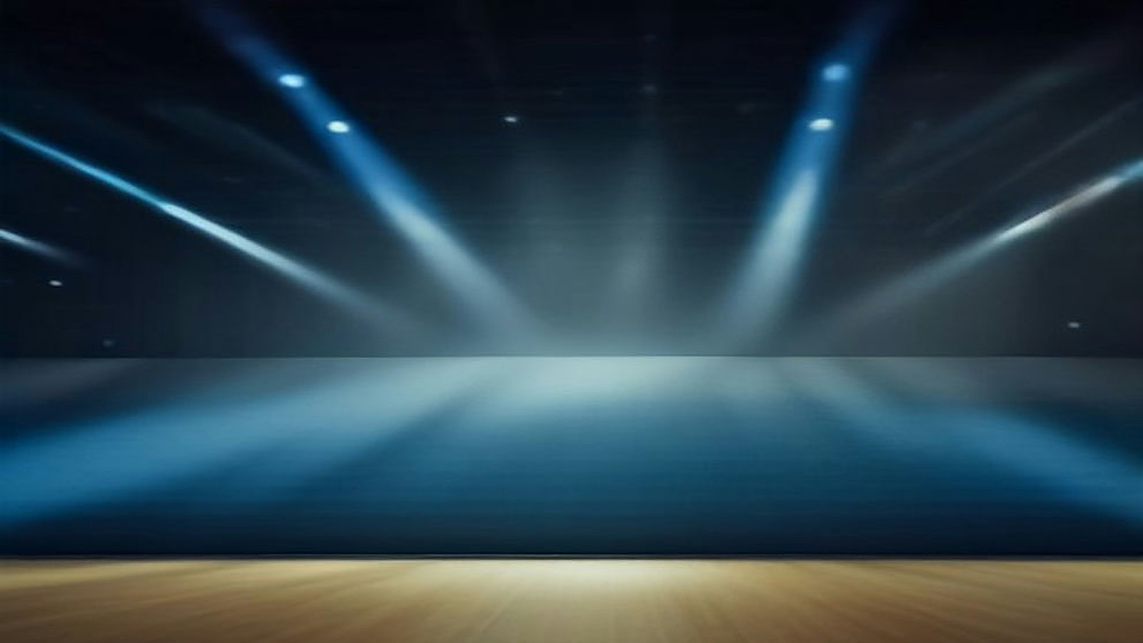 Recinto techado vacío preparado para un concierto con haces de luz azul que caen sobre el escenario entre humo